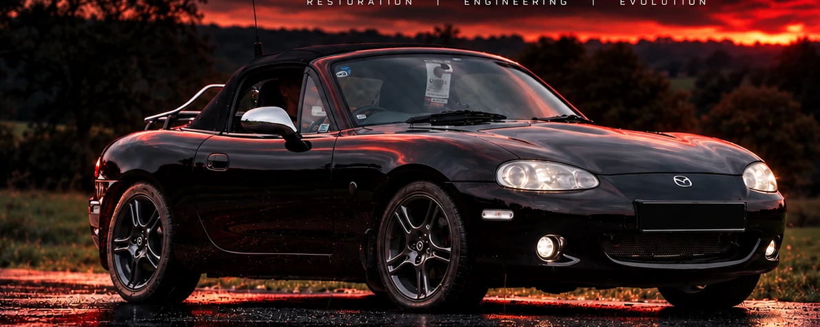 Project Nemesis, black MX-5 with registration plate obscured, in cinematic red dusk lighting
